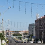 Aleja Niepodległości w Mińsku w słoneczny dzień, ruch samochodowy i kamienice