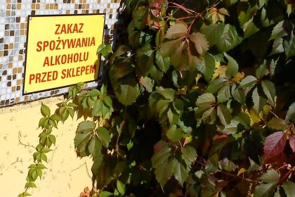 Tabliczka „Zakaz spożywania alkoholu przed sklepem” na ścianie sklepu w Poznaniu