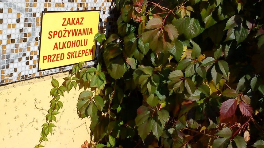 Tabliczka „Zakaz spożywania alkoholu przed sklepem” na ścianie sklepu w Poznaniu