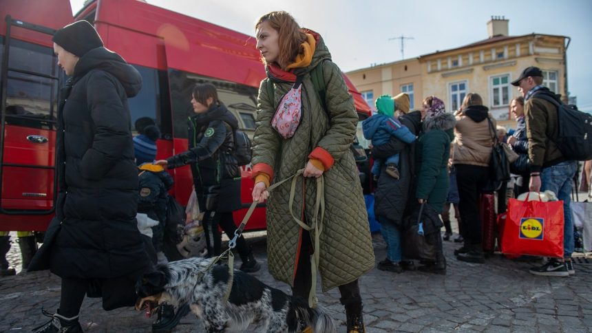 Uchodźcy z Ukrainy z bagażami przy punkcie recepcyjnym w Polsce